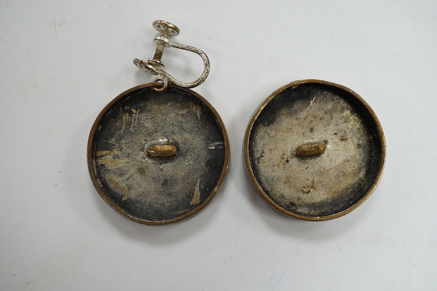 A pair of engraved gilt metal enamel and paste set disc shaped buttons)converted to earrings, one fitting missing), each decorated with a lady wearing a mask, diameter 25mm. Condition - poor to fair